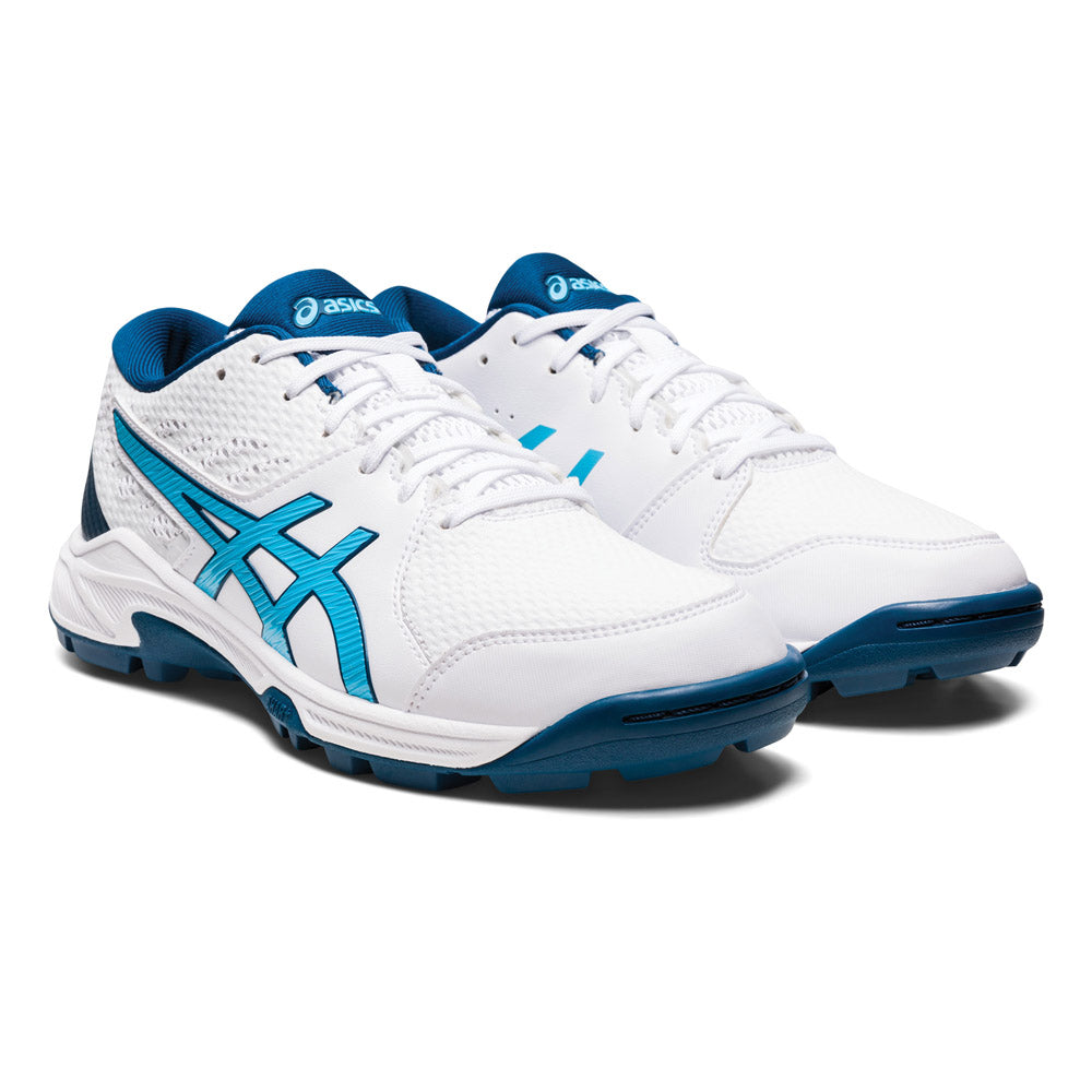 An angled view of a pair of women's ASICS GEL PEAKE 2 cricket shoes in white and aqua colours.