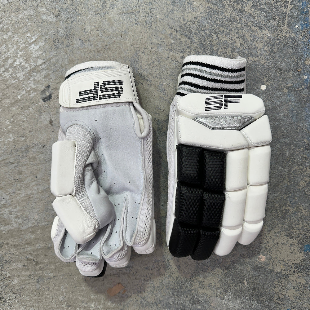 Pair of white and black gloves with 'SF' branding on a gray surface