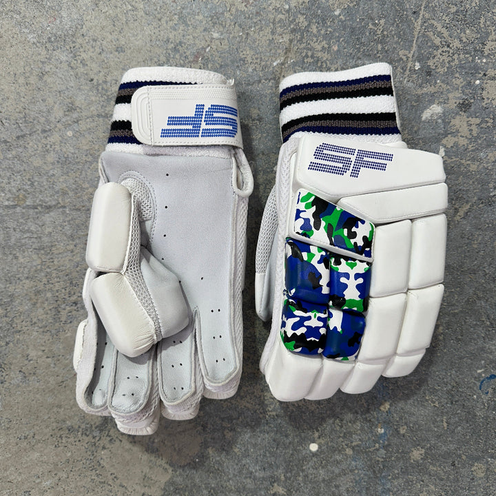 Pair of white SF cricket gloves with camouflage pattern on a gray surface