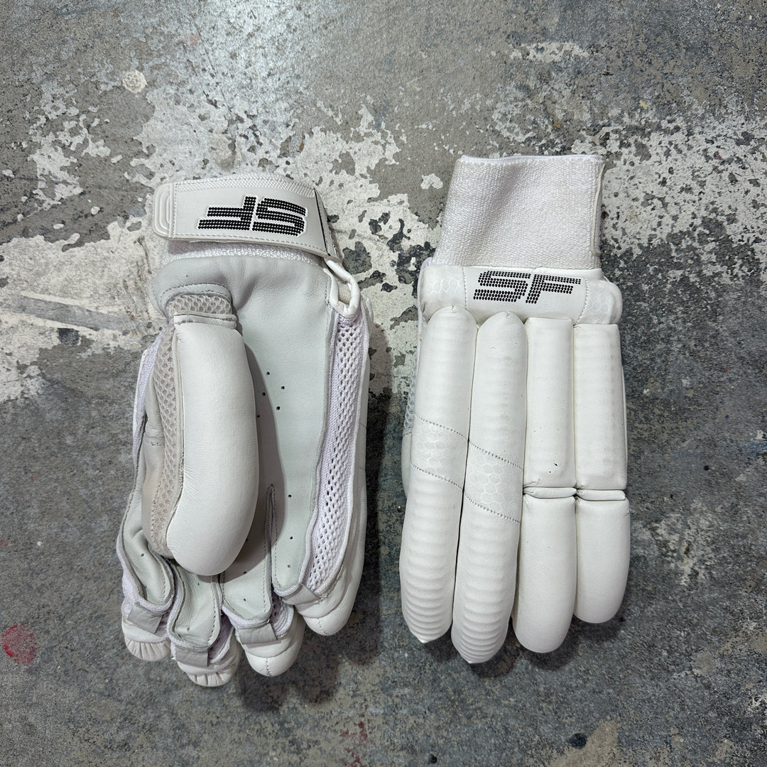 Pair of white cricket gloves with SF logo on a textured gray surface
