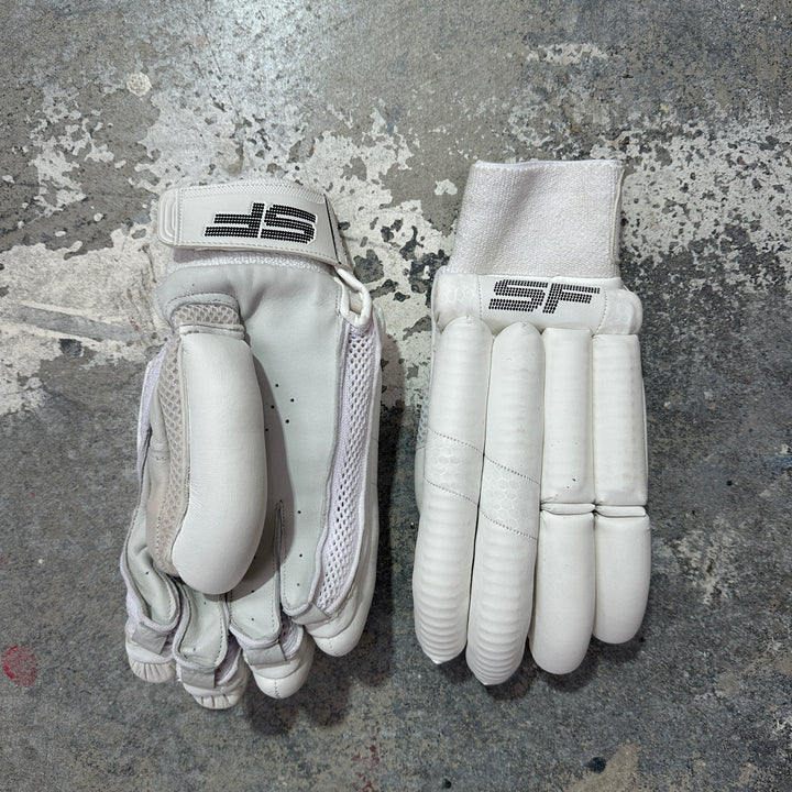 Pair of white cricket gloves with SF logo on a textured gray surface