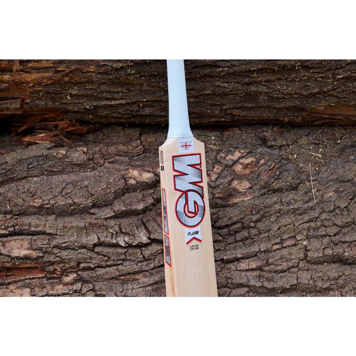 Wooden cricket bat with GM logo on a wooden background