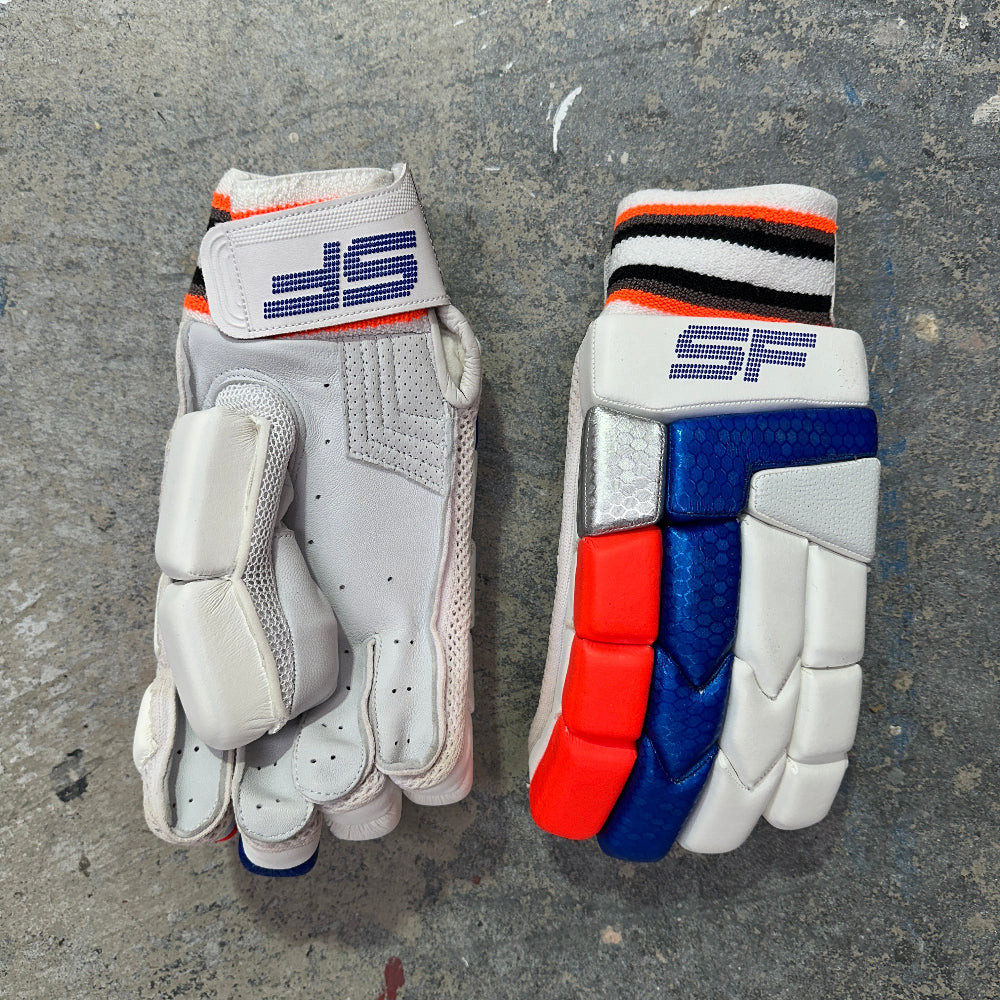 A pair of SF batting gloves with red, blue, and black accents on a gray surface