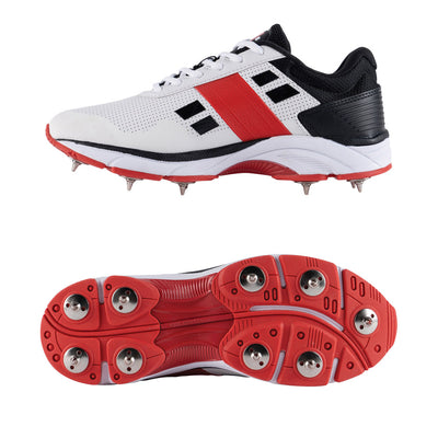 A pair of GN VELOCITY 4.0 Full Spike Cricket Shoes with white uppers, red soles, and black accents.