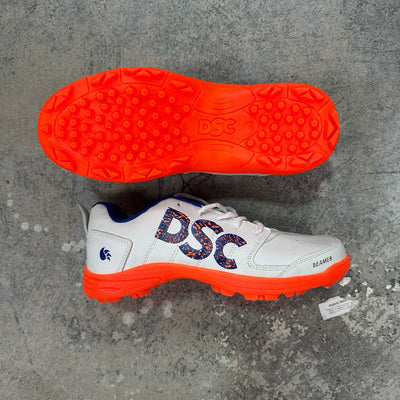 White sports shoe with orange sole & DSC branding on a gray concrete surface