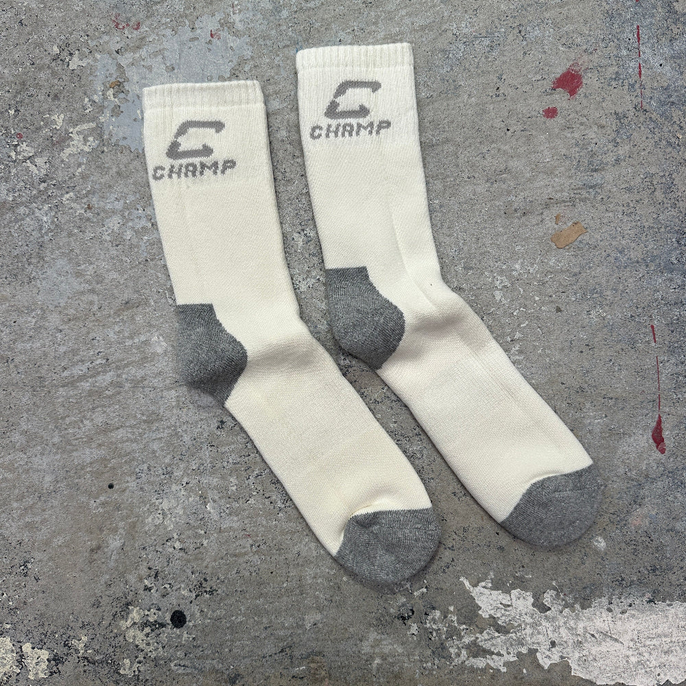 White socks with gray toes and heels on a textured gray surface