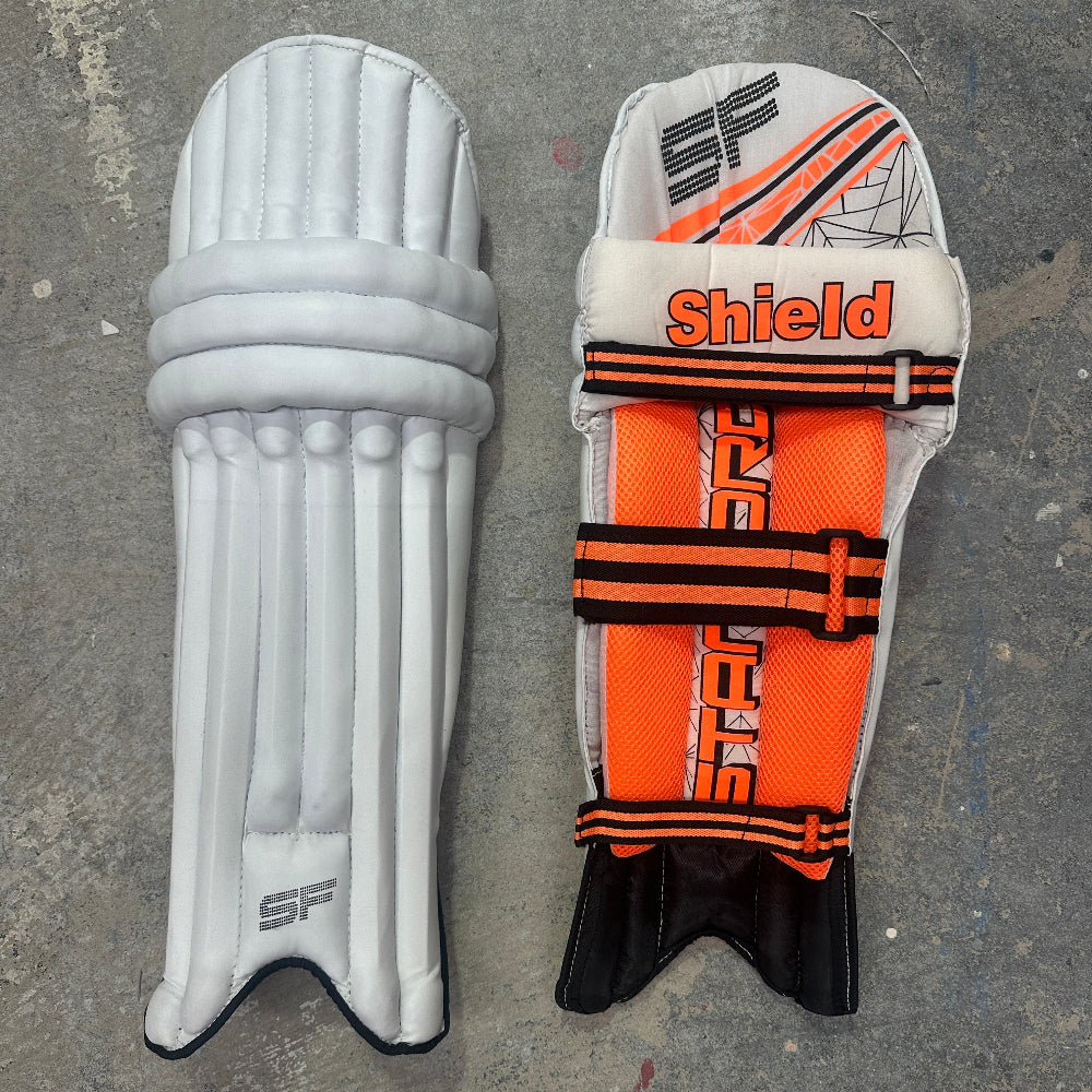 Pair of SF cricket pads with 'Shield' branding on a gray surface