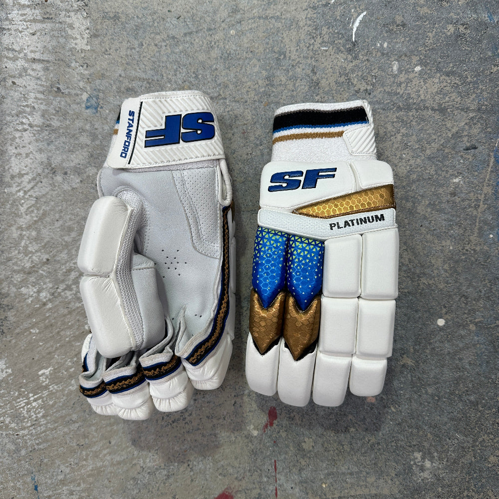 SF batting gloves with blue and gold accents on a gray surface