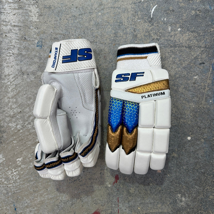 SF batting gloves with blue and gold accents on a gray surface