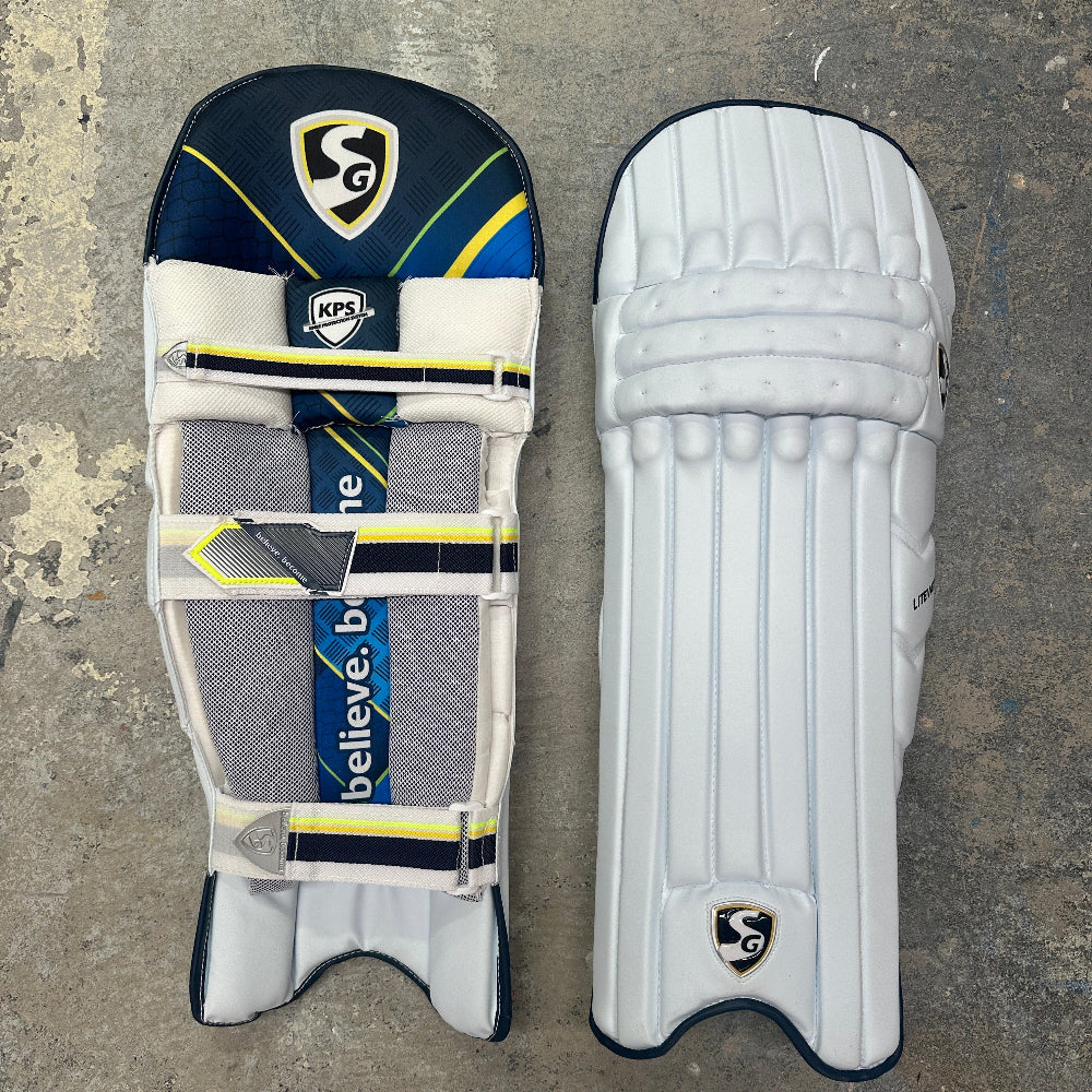 Pair of cricket pads with visible SG branding on a textured surface