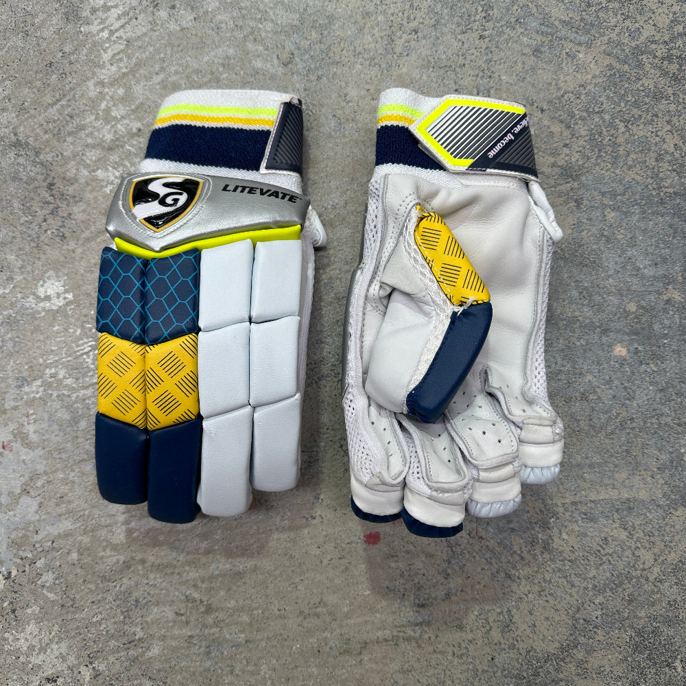 Pair of white gloves with blue and yellow accents on a gray surface