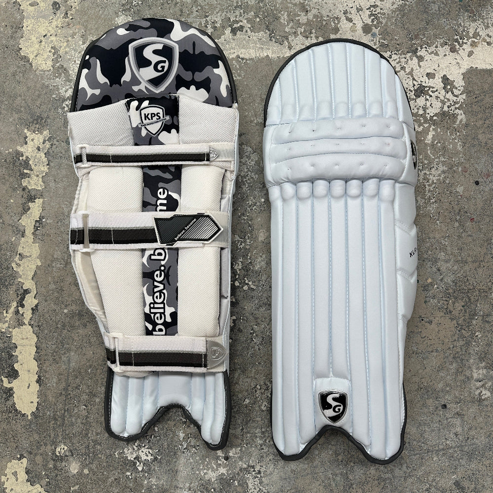 Pair of SG cricket pads with visible branding on a textured surface