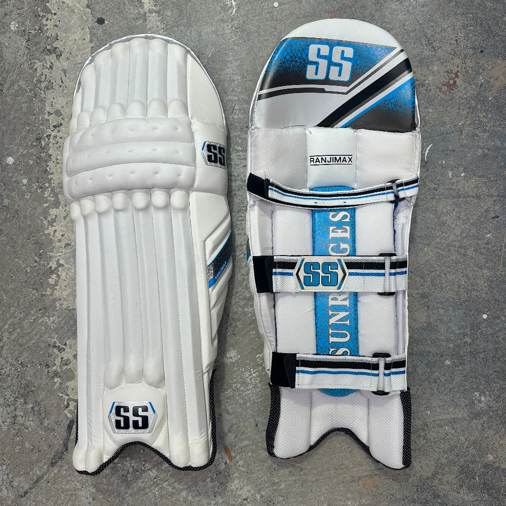 Pair of cricket pads with 'SS' branding on a gray surface