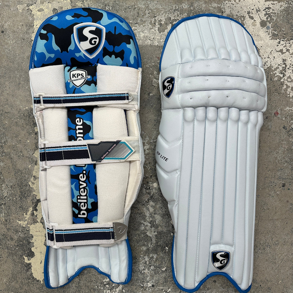 Pair of SG cricket pads with blue and white design on a textured surface