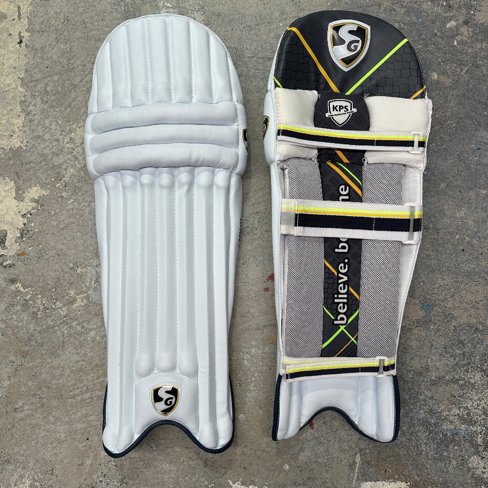 Pair of cricket pads with the SG brand logo on a concrete surface