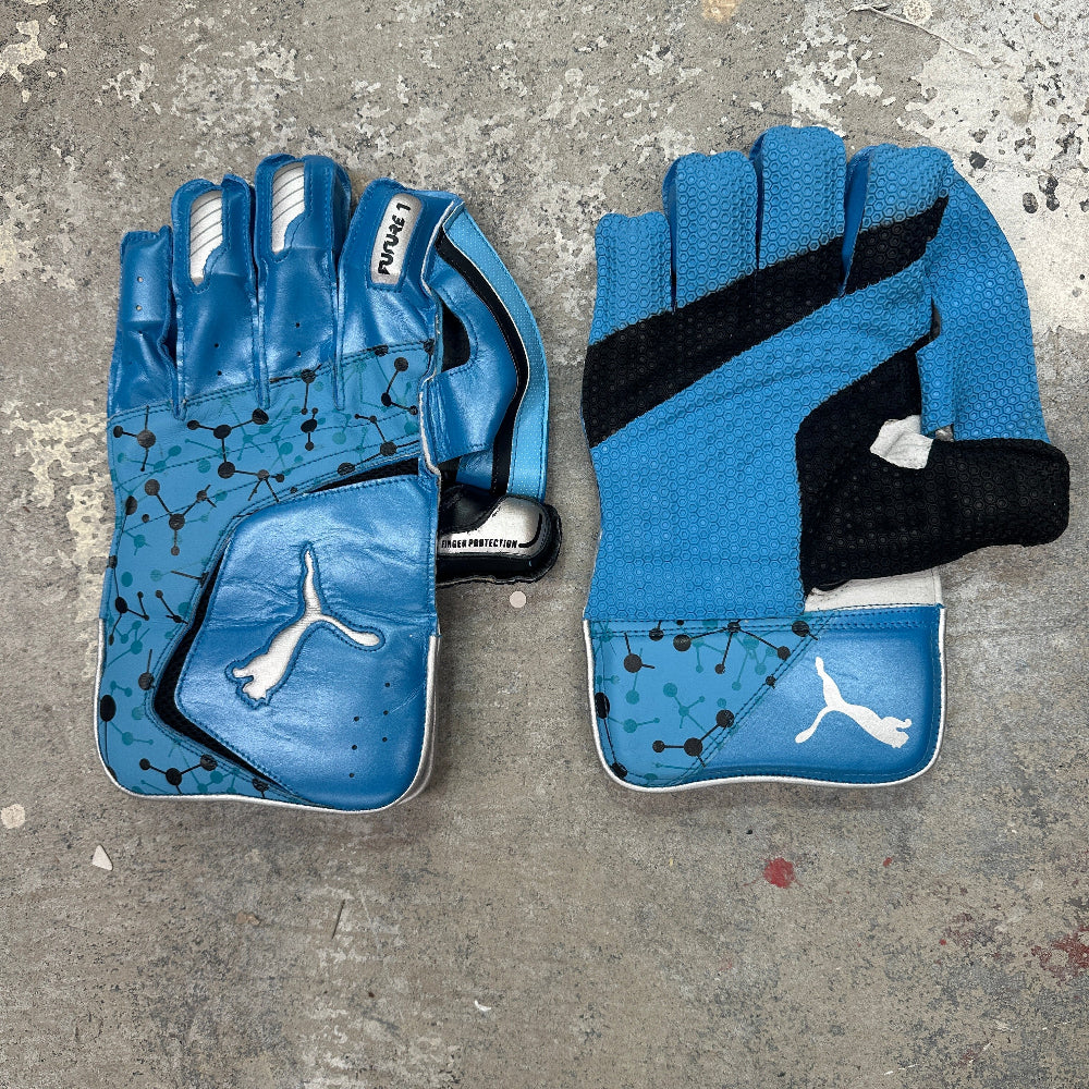 Pair of blue PUMA keeping gloves with black accents on a gray surface