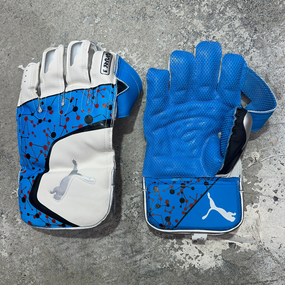 Pair of blue and white keeping gloves with Puma logo on a gray surface